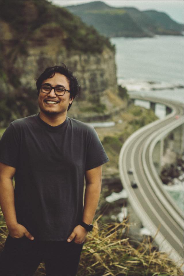 Samit Tandukar standing beside a coastal road
